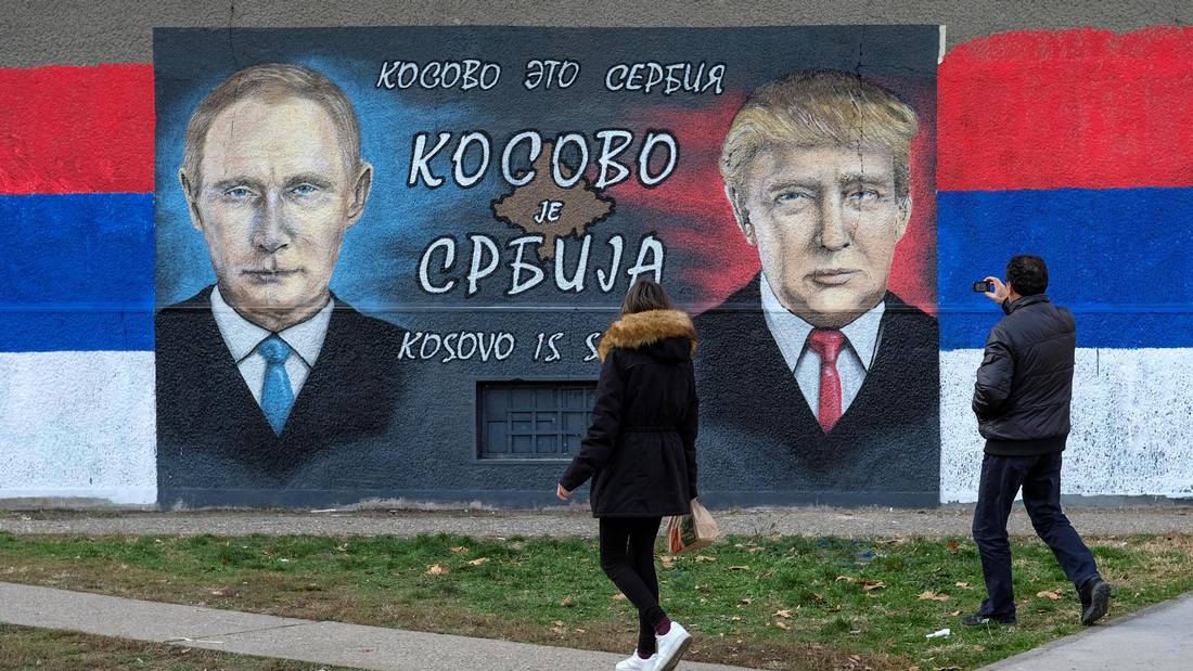 A man takes pictures of a mural of Russian President Vladimir Putin and U.S. President Donald Trump in Belgrade in December. REUTERS